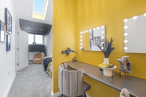 a room with a yellow wall with a counter and chairs at Mystic Heights- Wyndale Signature Stays in Worcester