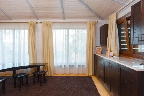 una cucina con tavolo, sedie e finestra di Poiana Bradului Complex Hotelier & Restaurant a Chişinău