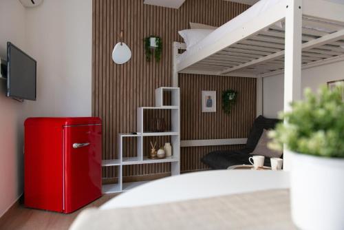 a red refrigerator in a living room with a couch at Lætitia Cottage Apartment in Aversa