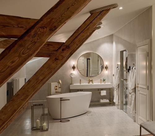 a bathroom with a large white tub and a sink at The Hotel Maria Helsinki in Helsinki
