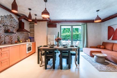 a kitchen and living room with a table and a couch at Rezydencja Merwede Aparthotel - My Rest in Gdańsk
