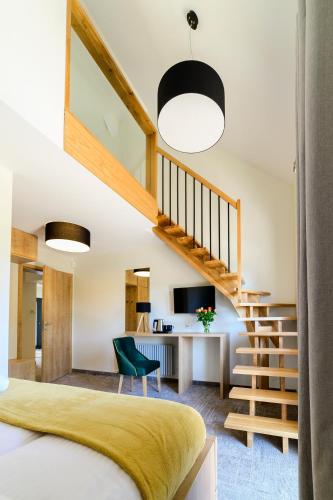 a bedroom with a staircase and a desk with a television at Aleksandra Resort in Tuchom