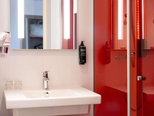 a bathroom with a white sink and a mirror at ibis Styles Toulouse Cite Espace in Toulouse