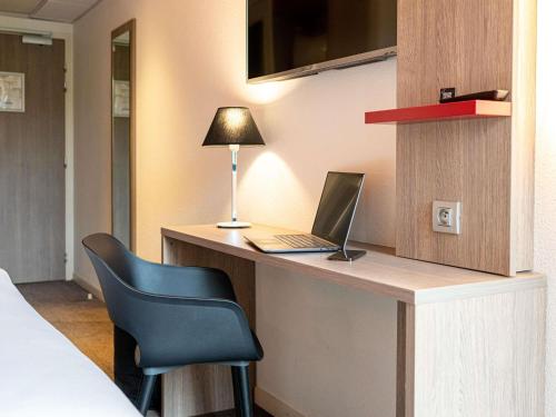 a room with a desk with a laptop and a chair at ibis Styles Toulouse Cite Espace in Toulouse