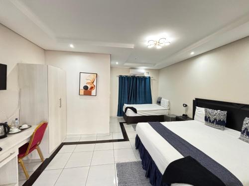 a hotel room with a bed and a desk at R&H Guest House in Kasane
