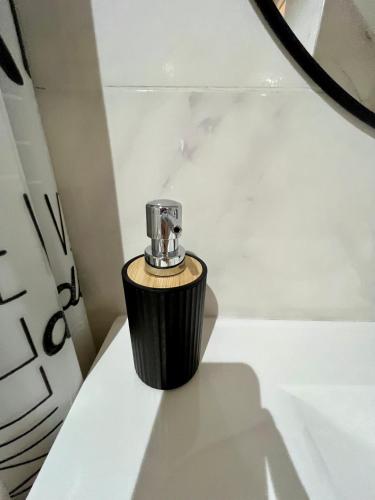 a soap dispenser sitting on a table in a bathroom at APART TRAVEL SUITES, modernos departamentos -15 min Aerop EZE in Monte Grande