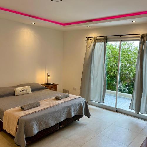 a bedroom with a bed and a large window at APART TRAVEL SUITES, modernos departamentos -15 min Aerop EZE in Monte Grande