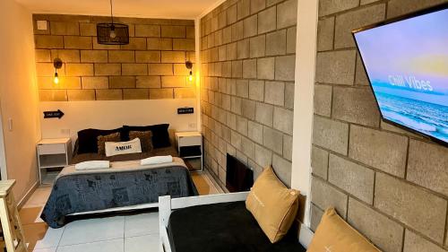 a room with a bed and a tv on a wall at APART TRAVEL SUITES, modernos departamentos -15 min Aerop EZE in Monte Grande