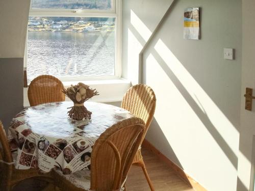 a dining room with a table and a window at Fleet Cottage in Portree
