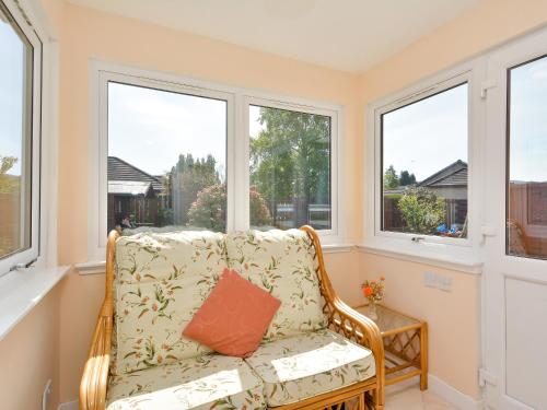 a wicker chair in a room with windows at Westburn in Comrie