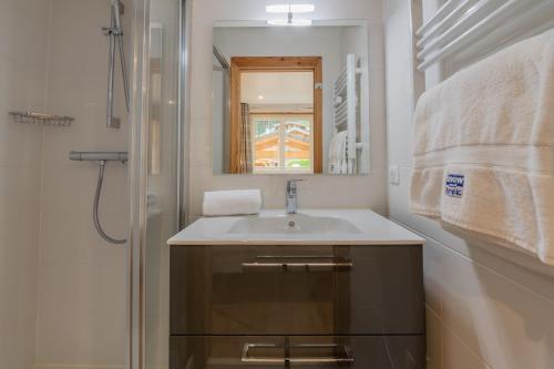 un baño con lavabo y espejo en Montana 102 Apartment - Snow and Trek - Montriond, en Morzine