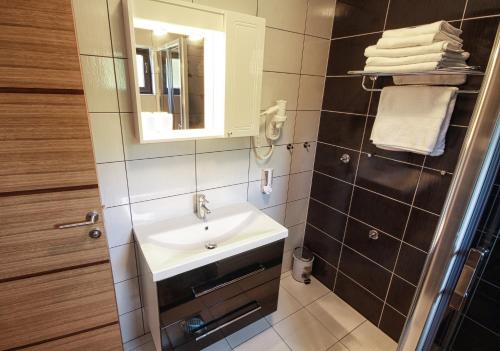 a bathroom with a sink and a mirror and towels at Countryside Apartment in Rakovica