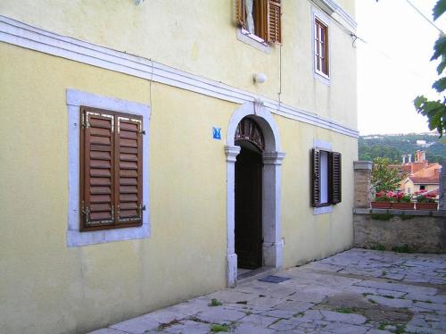 a yellow building with a door and a window at Apartments Camellia & Magnolia in Volosko
