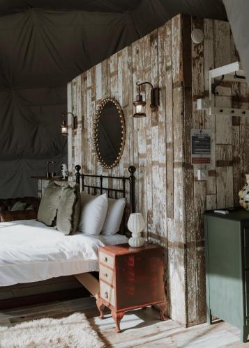 a bedroom with a bed and a mirror on a wall at Star Gazing Dome 3 with Log Burner & Optional Hot tub in Horspath