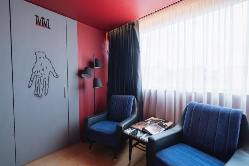 two chairs and a table in a room with a window at Burgus Tribute & Design Hotel in Braga