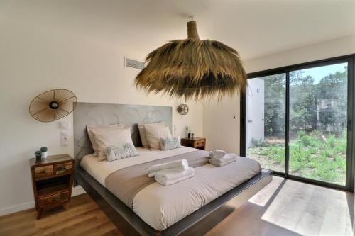 a bedroom with a large bed with a large window at Villa d'exception à Mauguio Piscine chauffée in Mauguio