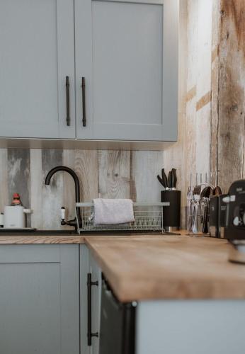 a kitchen with white cabinets and a sink at Star Gazing Dome 3 with Log Burner & Optional Hot tub in Horspath