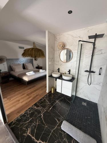 a bathroom with two sinks and a bed in a room at Villa d'exception à Mauguio Piscine chauffée in Mauguio