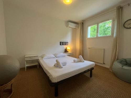 a bedroom with a white bed and a window at Belle villa calme, parking, jardin, Climatisation in Biarritz