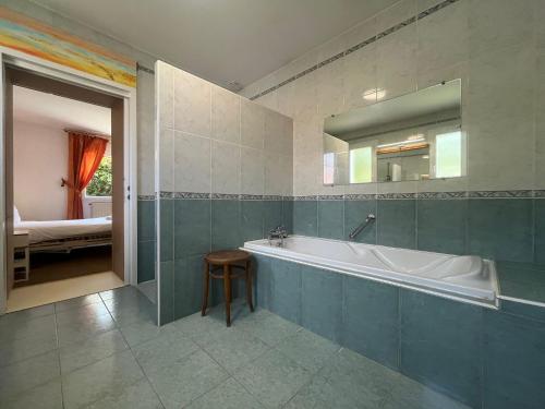 a bathroom with a tub and a bedroom with a bed at Belle villa calme, parking, jardin, Climatisation in Biarritz