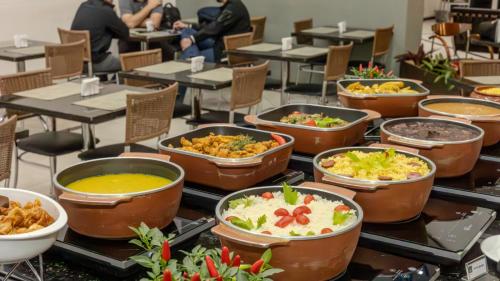 a buffet of different types of food on tables at Nobile Inn Jundiaí in Jundiaí
