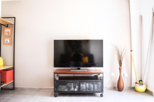 ein Flachbildfernseher auf einem Ständer in einem Wohnzimmer in der Unterkunft Ola Azul Bungalow in Benidorm