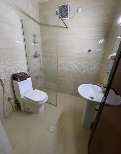 a bathroom with a toilet and a sink and a shower at Apartment near bus station & market MEN only in Sharjah