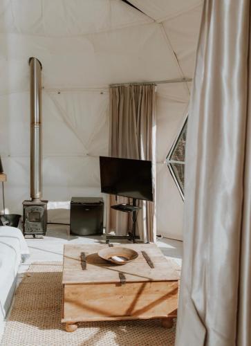 a living room with a table in a tent at Star Gazing Dome 1 with cozy log burner in Horspath