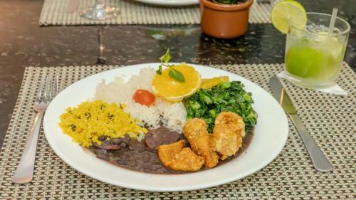 a plate of food with rice and meat and vegetables at Nobile Inn Jundiaí in Jundiaí