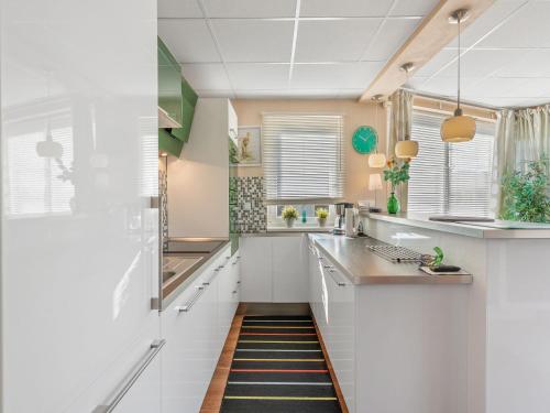 a kitchen with white cabinets and a rug on the floor at Apartment U Rybníka by Interhome in Stříbrná Skalice