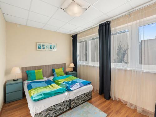 a bedroom with a bed with blue and green pillows at Apartment U Rybníka by Interhome in Stříbrná Skalice