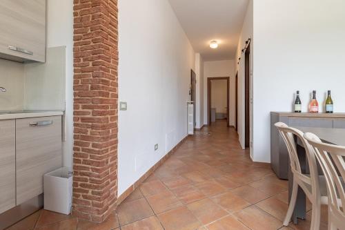 a kitchen with a brick wall and a table and chairs at Zardo Winery 2 in San Pietro in Cariano