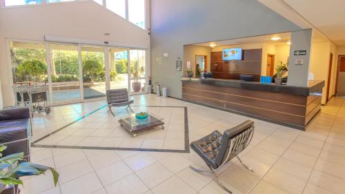 a lobby with a waiting area with chairs and a table at Nobile Inn Jundiaí in Jundiaí
