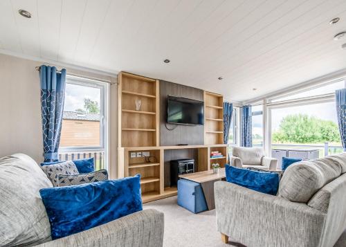 a living room with two couches and a tv at Hanworth Country Park in Potter Hanworth