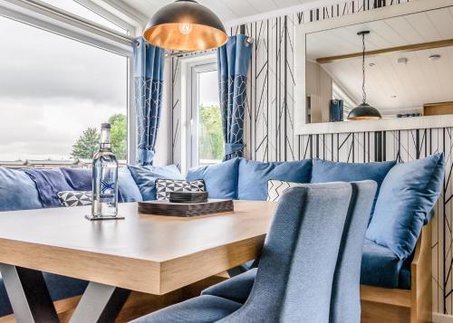 a living room with a blue couch and a wooden table at Hanworth Country Park in Potter Hanworth