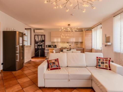 a living room with a white couch and a kitchen at Apartment Residenza Elisa by Interhome in Rovellasca