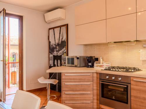 a kitchen with a counter with a microwave and a stove at Apartment Residenza Elisa by Interhome in Rovellasca