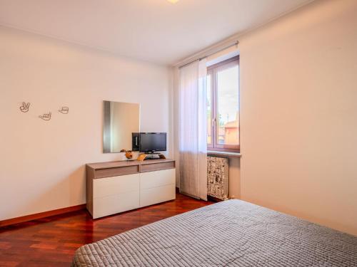 a bedroom with a bed and a tv and a window at Apartment Residenza Elisa by Interhome in Rovellasca