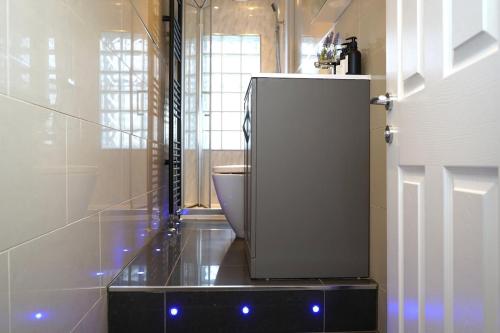 a bathroom with a toilet and a white refrigerator at Modern 3-Bed Flat Prime Falkirk Location in Falkirk