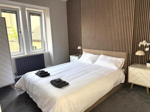a bedroom with a bed with two towels on it at Modern 3-Bed Flat Prime Falkirk Location in Falkirk