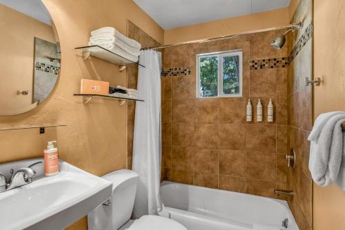 a bathroom with a sink and a toilet and a tub at Creekside Juanita's Place - 51 E 200 in Moab