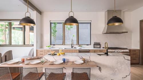 a kitchen with a table with chairs and two pendant lights at Riverlight Lodge in Steamboat Springs