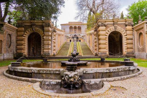 a fountain in the middle of a building with a staircase at La Cocca Via Saffi, con vasca in camera in Viterbo