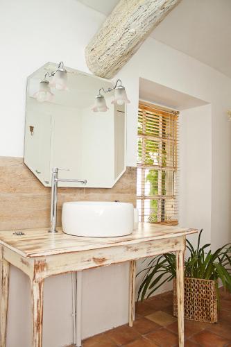 une salle de bain avec un lavabo et un miroir dans l'établissement Maison Saint Louis avec Jacuzzi, à Besse-sur-Issole