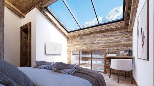 a bedroom with a bed and a large window at Chalet unique haut de gamme au centre de La Clusaz in La Clusaz