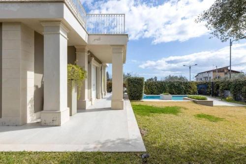 a white house with a walkway in a yard at Dream Villa in Izola - Pure Relaxation with Private Pool in Izola