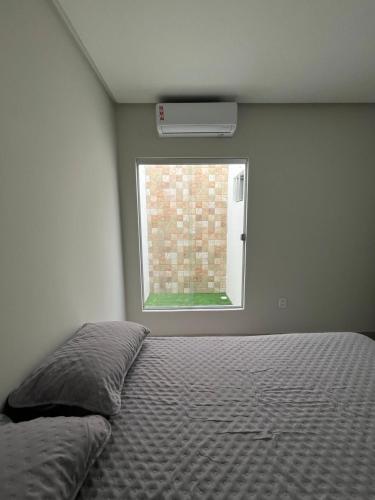 a bedroom with a bed and a window at CF Flat 03 in Petrolina