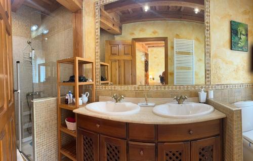 Un baño con dos lavabos y un espejo grande. en Casa Vega Bayo, en Fuentelcésped