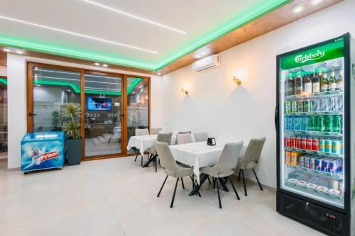 a restaurant with a table and chairs and a drink refrigerator at Apart-Hotel President 2 in Ulcinj