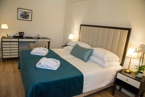 a bedroom with a bed with towels on it at Luna Hotel de Tábua in Tábua
